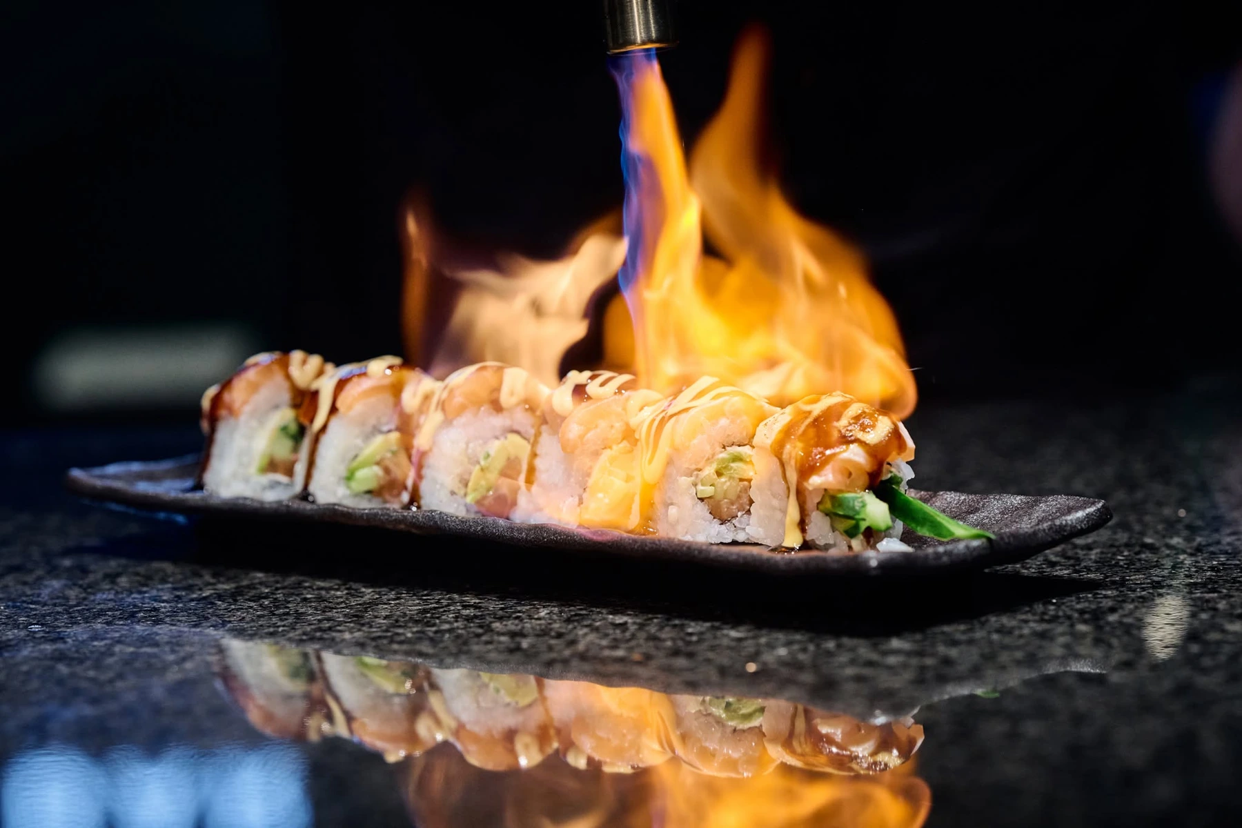 A Sabi saját ételfotója: lánggal pirított lazacos sushi fekete kerámiatálon